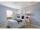 Tranquil bedroom with soft blue walls, cozy bedding, and a bright window providing natural light at 12031 Longview Lake Cir, Lakewood Ranch, FL 34211