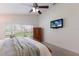Bedroom features include a ceiling fan, a mounted TV, and a large window with views of the outdoors at 12031 Longview Lake Cir, Lakewood Ranch, FL 34211