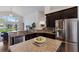 Well-equipped kitchen with granite countertops, stainless steel appliances, dark cabinetry, and water views at 12031 Longview Lake Cir, Lakewood Ranch, FL 34211