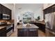 Open-concept kitchen with dark cabinets, granite counters, stainless steel appliances, and views to the water at 12031 Longview Lake Cir, Lakewood Ranch, FL 34211