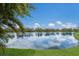 Beautiful lake view with clear sky reflecting on the water, framed by green grass at 12031 Longview Lake Cir, Lakewood Ranch, FL 34211