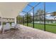 Screened-in lanai with brick flooring and seating area overlooking a serene lake at 12031 Longview Lake Cir, Lakewood Ranch, FL 34211