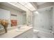 Well lit bathroom boasting a shower-tub combo and vanity with floral accent wall at 1207 71St Nw St, Bradenton, FL 34209