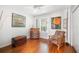 Comfortable bedroom featuring wood floors, a ceiling fan, natural light, and a unique chair with a cool art collection at 1207 71St Nw St, Bradenton, FL 34209