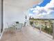 A patio table with seating on a tiled balcony overlooking a scenic waterfront neighborhood with city skyline at 1233 N Gulfstream Ave # 401, Sarasota, FL 34236