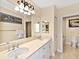 Bright bathroom featuring double sinks with marble countertop and elegant light fixture above at 1233 N Gulfstream Ave # 401, Sarasota, FL 34236