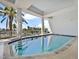 Beautiful indoor pool area with waterfront view, seating, and palm trees at 1233 N Gulfstream Ave # 401, Sarasota, FL 34236