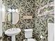 Charming powder room with decorative wallpaper, pedestal sink, and elegant lighting at 1233 N Gulfstream Ave # 401, Sarasota, FL 34236