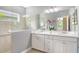 Bathroom featuring double sinks, modern vanity, and a walk-in shower with glass enclosure at 12331 Halfmoon Lake Ter, Bradenton, FL 34211