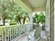 Cozy front porch with chairs, perfect for enjoying a morning coffee or evening sunset with views of trees and greenery at 12331 Halfmoon Lake Ter, Bradenton, FL 34211