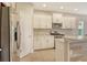 Well-lit kitchen featuring white cabinets, stainless steel appliances, and a stylish backsplash, and breakfast bar at 12331 Halfmoon Lake Ter, Bradenton, FL 34211