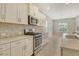 Bright kitchen with stainless steel appliances, white cabinets, tile backsplash and granite countertops at 12331 Halfmoon Lake Ter, Bradenton, FL 34211