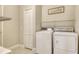 Well-lit laundry room with a white washer and dryer and ample shelving at 12331 Halfmoon Lake Ter, Bradenton, FL 34211