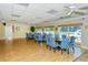 A bright dining room featuring nautical decor with round tables and blue-patterned chairs, offering a view of the pool area at 1350 N Portofino Dr # 402, Sarasota, FL 34242