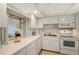 Bright kitchen with white cabinets, appliances, and a pass-through window to the dining area at 1350 N Portofino Dr # 402, Sarasota, FL 34242