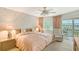 Cozy main bedroom with floral wallpaper, water view, and access to a private balcony at 1350 N Portofino Dr # 402, Sarasota, FL 34242