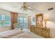 Main bedroom with water views, dresser, and access to the balcony with sitting area at 1350 N Portofino Dr # 402, Sarasota, FL 34242