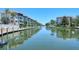 Wide view of a calm waterway framed by waterfront condos, boat docks, and lush green landscaping at 1350 N Portofino Dr # 402, Sarasota, FL 34242