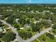Expansive aerial view of property featuring a home, lush greenery, a pond, and surrounding landscape at 13514 4Th E Plz, Bradenton, FL 34212
