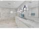 Elegant bathroom featuring a double vanity, marble counters, and a walk-in shower with tile surround at 13514 4Th E Plz, Bradenton, FL 34212