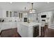 Well-lit kitchen featuring an island with a wine cooler, modern appliances, and hardwood floors at 13514 4Th E Plz, Bradenton, FL 34212