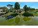 Scenic view of a tranquil pond, surrounded by lush trees and the residence, enhancing the property's allure at 13514 4Th E Plz, Bradenton, FL 34212