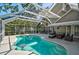Screened-in pool area featuring a large pool, ample seating, and lush landscaping at 13514 4Th E Plz, Bradenton, FL 34212