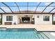 Backyard view of screened pool, outdoor dining area, and well-maintained home exterior at 13606 Deep Blue Pl, Bradenton, FL 34211