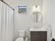 Modern bathroom with vanity, round mirror, white tile walls, and shower with curtain at 13606 Deep Blue Pl, Bradenton, FL 34211