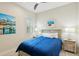 Cozy bedroom with bright blue bedding, decorative end tables, and natural light from shuttered window at 13606 Deep Blue Pl, Bradenton, FL 34211