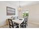 Bright dining room with modern light fixture, white wainscoting and plank flooring at 13606 Deep Blue Pl, Bradenton, FL 34211