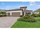 Beautiful single-story home featuring a brick driveway, three-car garage, and stone facade accent at 13606 Deep Blue Pl, Bradenton, FL 34211