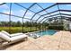 Inviting screened pool with relaxing in-pool lounge chairs overlooking the well-maintained backyard at 13606 Deep Blue Pl, Bradenton, FL 34211