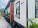 Side view of the building with white siding, black trim, and tropical landscaping at 1412 12Th W Ave, Bradenton, FL 34205