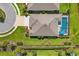 Aerial view of a home with a screened pool, lush backyard, and well-maintained landscaping at 16606 Barnwood Pl, Lakewood Ranch, FL 34211