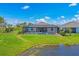 Lush green backyard featuring a screened pool and spa, adjacent to a peaceful pond at 16606 Barnwood Pl, Lakewood Ranch, FL 34211