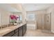 Bright bathroom featuring double sink with granite countertops, and an adjacent shower and bathtub at 16606 Barnwood Pl, Lakewood Ranch, FL 34211