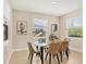 Bright dining room featuring a glass table, tan chairs, and views through three large windows at 16606 Barnwood Pl, Lakewood Ranch, FL 34211