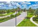 View of gated community entrance with lush landscaping, palm trees, and decorative brick pavers at 16606 Barnwood Pl, Lakewood Ranch, FL 34211