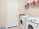 Functional laundry room equipped with modern washer and dryer, plus ample storage shelving at 16606 Barnwood Pl, Lakewood Ranch, FL 34211