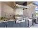 Close up of outdoor kitchen with sink, Lion grill and refrigerator, perfect for outdoor entertaining at 16606 Barnwood Pl, Lakewood Ranch, FL 34211
