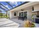 Covered patio area featuring an outdoor dining set and lush tropical landscaping at 16606 Barnwood Pl, Lakewood Ranch, FL 34211