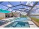 Inviting screened-in pool and spa area complete with outdoor kitchen, overlooking a tranquil lake view at 16606 Barnwood Pl, Lakewood Ranch, FL 34211