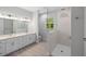 Bright bathroom boasts a double sink vanity, sleek fixtures, and glass-enclosed shower at 17113 Malta Ave, Port Charlotte, FL 33954