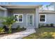 Inviting front entrance with beautiful landscaping, stone walkway, and a glass-paneled front door at 17113 Malta Ave, Port Charlotte, FL 33954