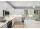 An open kitchen offers quartz countertops, stainless appliances, modern finishes, and an island at 17113 Malta Ave, Port Charlotte, FL 33954