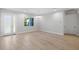 Bright, spacious living room featuring wood-look tile floors, a modern light fixture, and ample natural light at 17113 Malta Ave, Port Charlotte, FL 33954