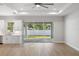 Spacious living space with wood-look tile, an open-concept kitchen, and sliding glass doors to the backyard at 17113 Malta Ave, Port Charlotte, FL 33954
