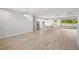 Open-concept living space showcasing wood-look tile floors, a modern kitchen with an island, and bright, neutral tones at 17113 Malta Ave, Port Charlotte, FL 33954