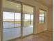 Balcony featuring large glass doors with views of green areas and blue water at 17715 Boracay Ct # 202, Venice, FL 34293